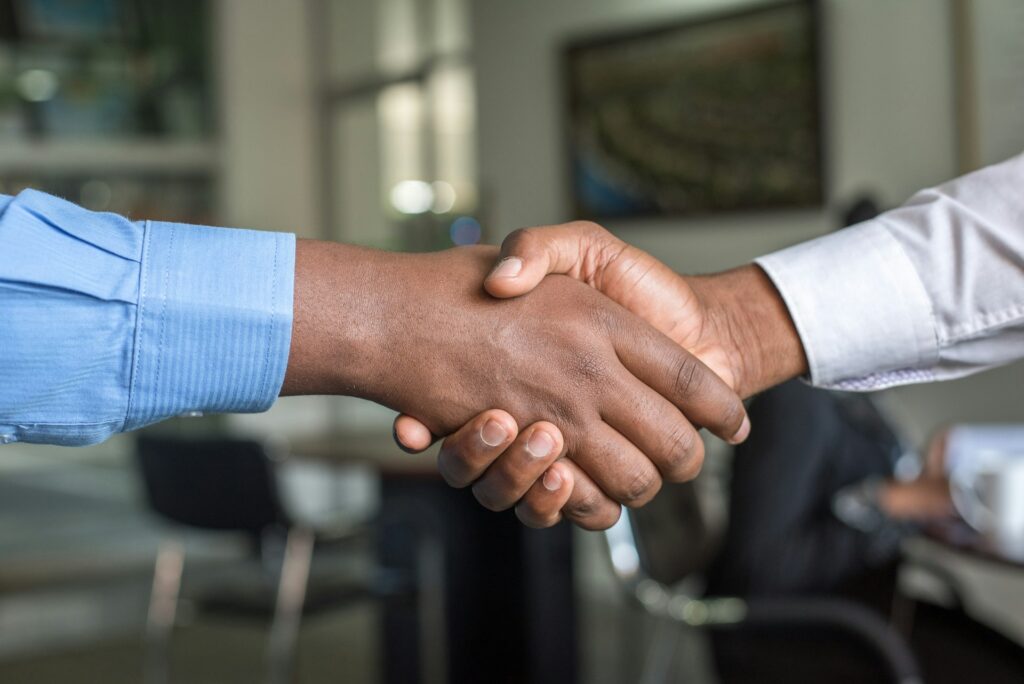 A close-up of two people shaking hands in a Nairobi office.
